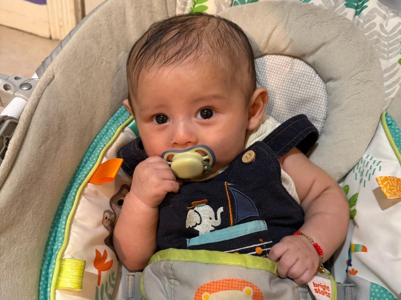 Infant resting in a cozy bouncer seat